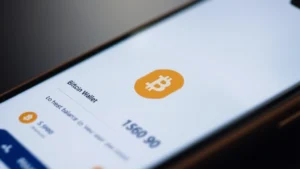 Close-up of a smartphone displaying a Bitcoin wallet application interface with balance visible, modern minimalist design, digital currency symbol glowing softly, professional crypto app aesthetic